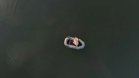 Aerial view one top At sunset. Fisherman sits in the boat. Stock Footage 100471592