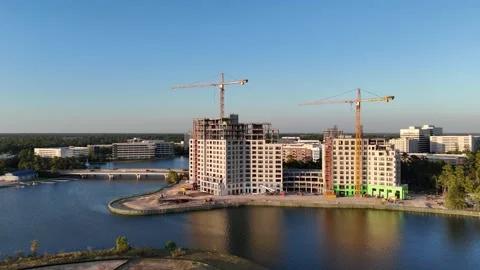 Aerial view of ongoing construction of two buildings in front of beautiful lake Stock Footage 336809432
