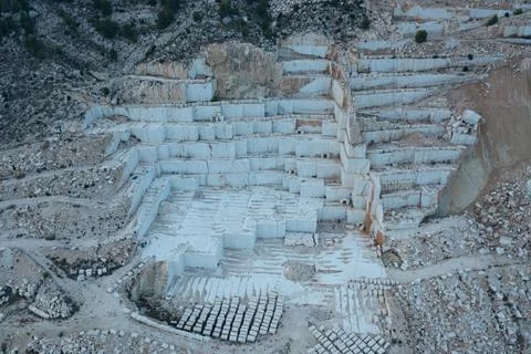 Aerial view of Open-air mining activity in a white marble mine. Stock Photos