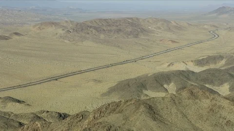 Aerial view of open desert Multi lane Highway long distance trucks carrying Stock Footage 76850068