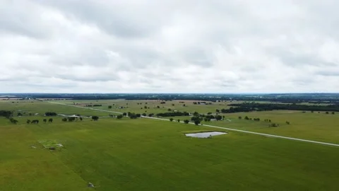 Aerial view of open fields and road as minimal traffic passes Stock Footage 156411562