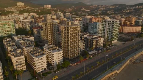 Aerial View: The open frame of a luxury building rises on the shoreline Stock Footage 296078608