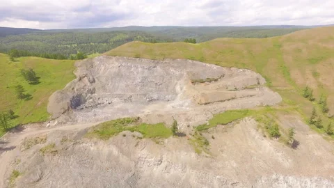 AERIAL: A view of the open pit for the extraction of gravel among the mountains Stock Footage 87148452