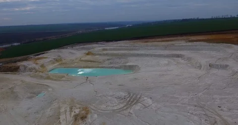 Aerial view of open pit kaolin clay mine with turquoise pool of water Stock Footage 127821126