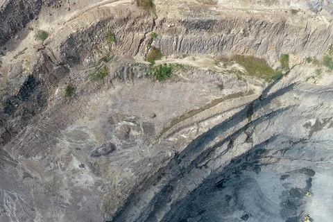 Aerial view of an open-pit mining site showing multiple stepped rock benche Stock Photos