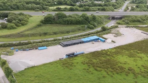 An aerial view of an open storage yard with stacks of pipes, located near Stockbeeldmateriaal 279139085