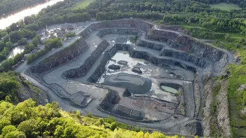 Aerial view of opencast mining quarry in the middle of the forest at sunrise Stock Footage 137276296