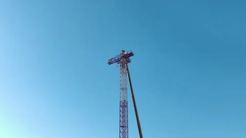 Aerial View: Operator climbs high ladders to mount crane parts precisely Stock Footage 296025302