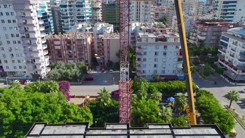 Aerial View: Operator climbs ladders, mounting crane parts with skill and Vídeo Stock 296021779