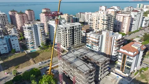 Aerial View: Operator scales ladders efficiently, mounting crane parts Vídeo Stock 296025016