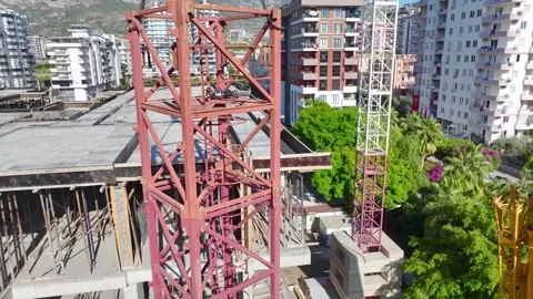 Aerial View: Operator works high above, assembling crane parts and climbing Vídeo Stock 296021573