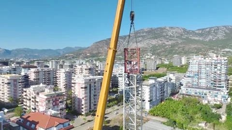 Aerial View: Operator works high above, mounting crane components and navigating Video stock 296022248