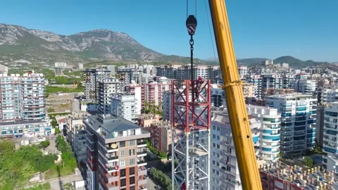 Aerial View: Operator works high above, assembling crane components with care Stock Footage 296022678