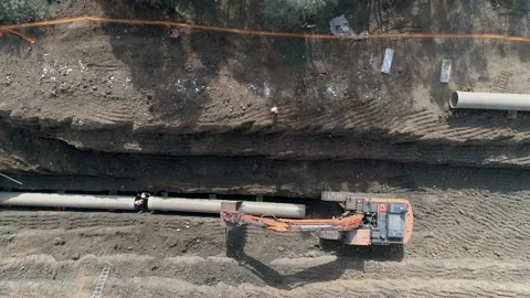 Aerial view of orange or red excavator tractor digging the sand ground to laying Stock Footage 131013059