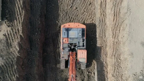 Aerial view of orange or red excavator tractor digging the sand ground to laying Stock Footage 131014321