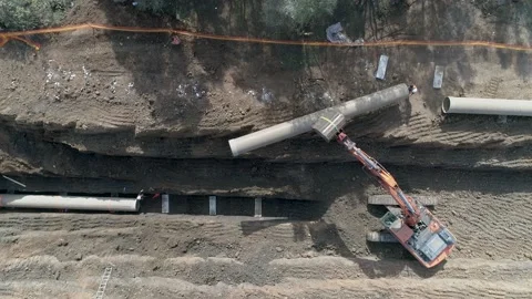 Aerial view of orange or red excavator tractor digging the sand ground to laying Stock Footage 131016289