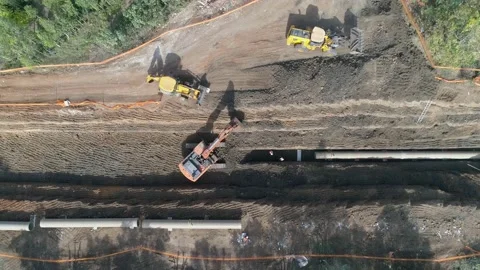 Aerial view of orange or red excavator tractor digging the sand ground to laying Stock Footage 131016906