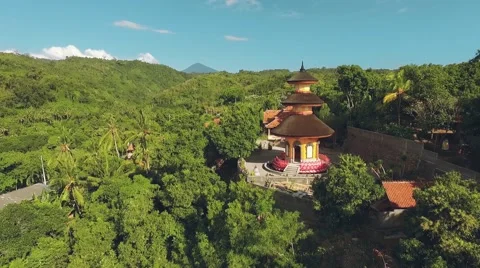 Aerial view of orange temple tower on green hill, Brahma Vihara Arama Monastery Stock Footage 68084185