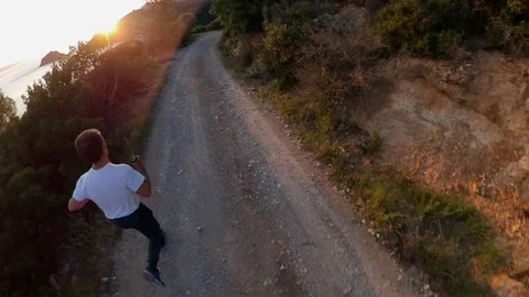Aerial view, orbit around a man jogging on a scenic path on the cliff at sunset Stock Footage 107968068