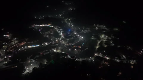 Aerial view orbiting the illuminated cityscape of Munnar hill station, India 動画素材 316806193