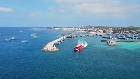 Aerial view orbiting a passenger vessel sailing through a blue bay 4K Stock Footage 336040023