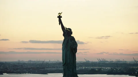 Aerial view of orbiting the Statue of Liberty to downtown Manhattan close to nig Stock Footage 199461109