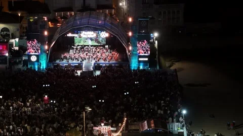 Aerial view of an orchestra performing on a beach in Cascais, Portugal. Stock Footage 345005555