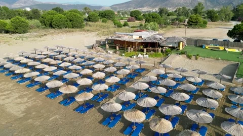 Aerial view of organized beach with straw umbrellas and blue sunbeds 스톡 동영상 333148674