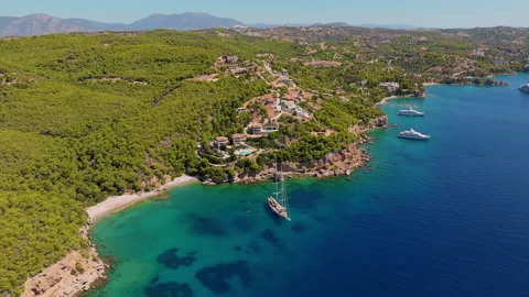 Aerial view of Ormos Luxury Villas perched on a lush pine-covered coastal Stock Footage 346298080
