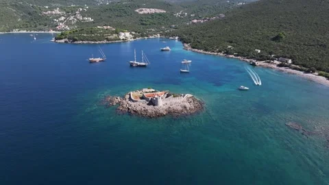 Aerial view of Otocic Gospa showcasing serene blue waters and sailing boats near Stock Footage 287786552