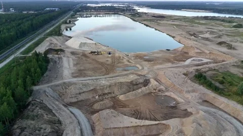 Aerial view over active sand quarry mining site with excavators and sand mounds Stock Footage 344757660