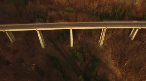 Aerial view over bridge at sunset with motorcycle passing in scene Stock Footage 63018663