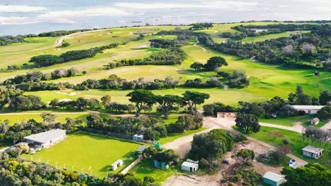Aerial View Over Coastal Golf Course and Green Rolling Hills Stock Footage 346573150