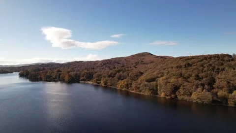 Aerial view over Coniston Water autumn shoreline in the Lake District, England Stock Footage 336493789