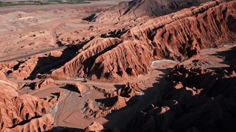 Aerial view over dramatic eroded salt rock badlands with winding dry riverbed Stock Footage 336266211