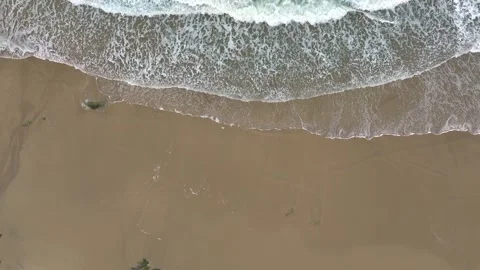Aerial View Over Foamy Waves Of The Sea Running Onto A Sandy Beach - Drone Shot Stock Footage 263730170