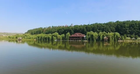 Aerial view over the forest areas and the lake among wooden restaurant Rest Area Stock Footage 212054478
