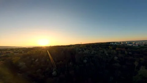 Aerial view over forest with view of university at sunset. Vidéo 238953206