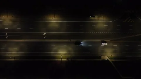 An aerial view over illuminated, parallel roads at night. The camera Stock Footage 223488512