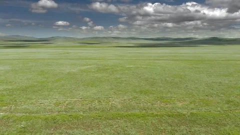 Aerial view over Mongolia steppe shows endless treeless plain - Rolling Terrain Stock Footage 339723205