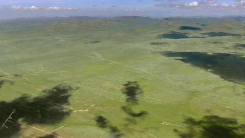 Aerial view over Mongolia steppe shows endless treeless plain - Remote Pasture Stock Footage 339723440