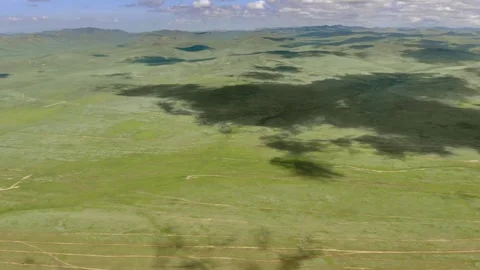 Aerial view over Mongolia steppe shows endless treeless plain - Open Grassland Stock Footage 339723478