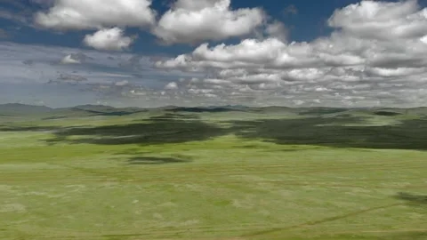 Aerial view over Mongolia steppe shows endless treeless plain - Spring Grassland Stock Footage 339723736
