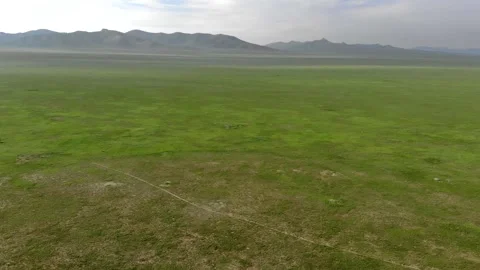 Aerial view over Mongolia steppe shows endless treeless plain - Open Countryside Stock Footage 339723866