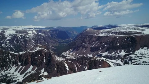 Aerial view over mountain top into deep valley in Beartooth Mountains Stock Footage 124226355