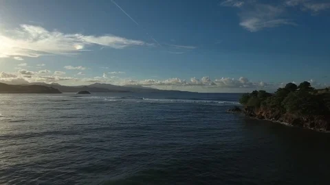 Aerial view over ocean with breaking waves, blue sky and sun, Martinique Stock Footage 82657246
