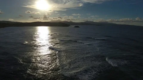 Aerial view over ocean with breaking waves, blue sky and sun, Martinique Stock Footage 82657248