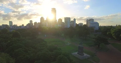 Aerial view over a park looking towards sunset and buildings in Buenos Aires. Stock Footage 77818874