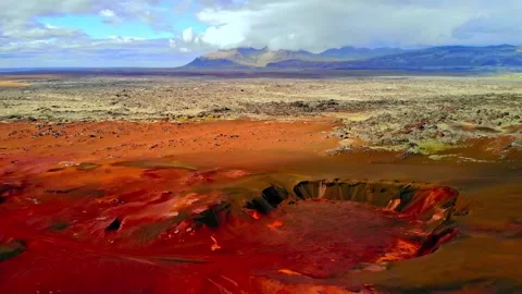 Aerial view over red volcanic crater and barren desert landscape showcasing Stock Footage 343695806