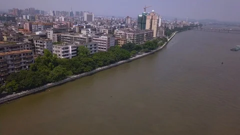 Aerial view over a river and a developing small town 動画素材 108602807